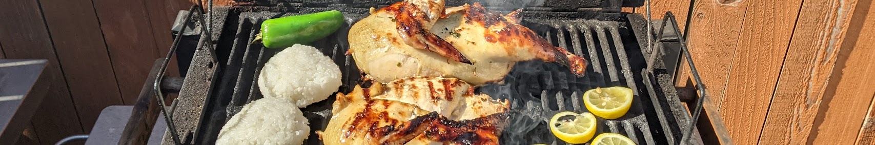 Grill with chicken, rice balls, and lemons