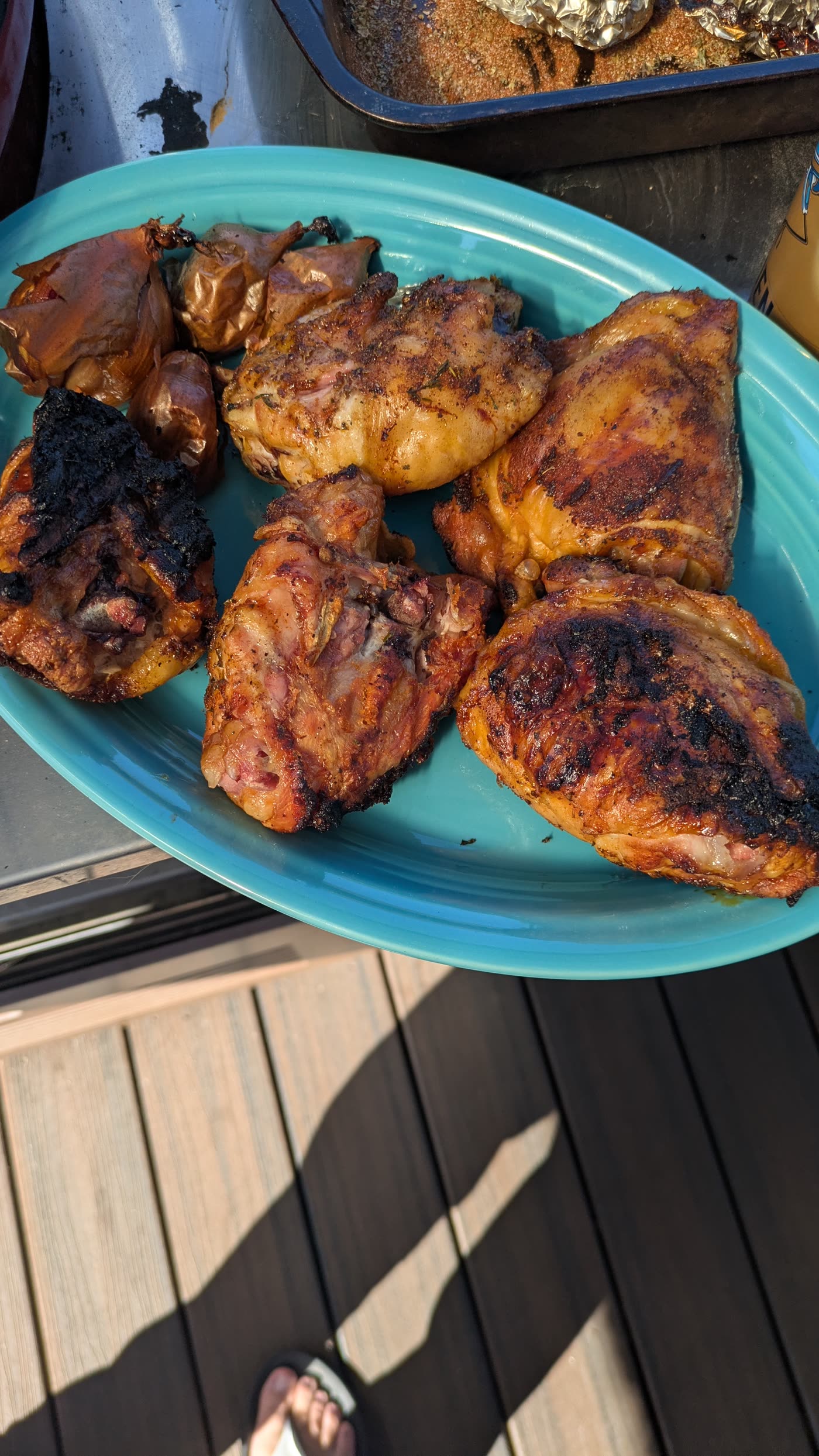 Grilled chicken thighs on a blue plate with crispy charred skin